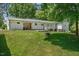 Backyard view with manicured lawn, a covered patio, and an inviting fire pit, ideal for outdoor gatherings at 6022 Little Creek Church Rd, Clayton, NC 27520