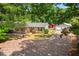 Spacious home with a long covered porch, detached garage, and a shed, all nestled among mature trees at 6022 Little Creek Church Rd, Clayton, NC 27520