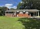 Classic brick home featuring a cozy front porch and an attached covered carport for convenient parking at 607 S Smithfield Rd, Knightdale, NC 27545