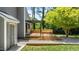 Gray home's inviting backyard showcases a wood deck and a black steel pergola at 7309 Forest Glade Ct, Raleigh, NC 27615