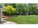 Backyard featuring a lush lawn, mature trees, and an outbuilding with large windows at 7309 Forest Glade Ct, Raleigh, NC 27615
