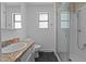 Bright bathroom with granite sink, glass shower, and sleek black tile flooring at 7309 Forest Glade Ct, Raleigh, NC 27615