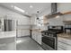 Bright kitchen with stainless steel appliances, granite countertops, white cabinetry, and modern lighting fixtures at 7309 Forest Glade Ct, Raleigh, NC 27615