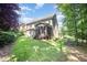 Spacious backyard view featuring a screened-in porch and a lush lawn surrounded by trees at 7809 Chestnut Branch Ct, Raleigh, NC 27612