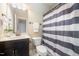 Bathroom featuring a dark wood vanity with a white marble countertop and a shower with a striped curtain at 7809 Chestnut Branch Ct, Raleigh, NC 27612