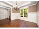 Bright dining room featuring wainscoting, hardwood floors, and a stylish chandelier at 7809 Chestnut Branch Ct, Raleigh, NC 27612