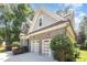 Side view of the home shows a spacious two-car garage and well-maintained landscaping at 7809 Chestnut Branch Ct, Raleigh, NC 27612