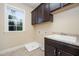 Well-lit laundry room with ample storage and a utility sink at 7809 Chestnut Branch Ct, Raleigh, NC 27612