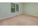 Cozy carpeted bedroom with ample natural light through the large window and pale-green walls at 8 Mandy Ct, Durham, NC 27707