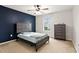 This cozy bedroom features a dark accent wall, carpeted floor, and a ceiling fan at 8005 Caithness St, Raleigh, NC 27616