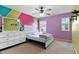 Bedroom with a pink accent wall, carpeted floor, ceiling fan, and dresser at 8005 Caithness St, Raleigh, NC 27616