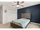 Bedroom features a dark accent wall, carpeted floor, ceiling fan, and closet at 8005 Caithness St, Raleigh, NC 27616