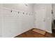 Welcoming foyer features wood floors and a shiplap accent wall with coat hooks at 8005 Caithness St, Raleigh, NC 27616