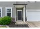 Close-up of the front door featuring stone accents, gray siding, and well-kept landscaping at 8005 Caithness St, Raleigh, NC 27616