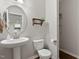 Well-lit half bathroom features a stylish pedestal sink and modern fixtures, ensuring convenience for guests at 8005 Caithness St, Raleigh, NC 27616