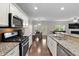 Modern kitchen features granite counters, stainless steel appliances, and wood floors at 8005 Caithness St, Raleigh, NC 27616