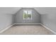 Finished attic space with a window, carpeted floor, and fresh paint at 81 Northcliff Ct, Clayton, NC 27527