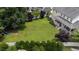 Aerial view of a backyard with a large lawn, white fence, and mature trees at 81 Northcliff Ct, Clayton, NC 27527