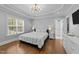 Primary bedroom with a trey ceiling, chandelier, hardwood floors and large window at 81 Northcliff Ct, Clayton, NC 27527