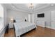 Primary bedroom with a trey ceiling, chandelier, hardwood floors and a view of TV at 81 Northcliff Ct, Clayton, NC 27527
