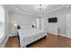 Primary bedroom with a trey ceiling, chandelier, hardwood floors and TV at 81 Northcliff Ct, Clayton, NC 27527