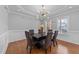 Dining room features a modern chandelier, elegant wainscoting, and hardwood floors at 81 Northcliff Ct, Clayton, NC 27527