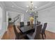 Open dining room with elegant lighting, dark wood table, and view of the staircase at 81 Northcliff Ct, Clayton, NC 27527