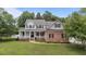 Inviting two-story home with a charming covered front porch, brick accents, and well-maintained landscaping at 81 Northcliff Ct, Clayton, NC 27527