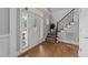 Bright foyer with hardwood floors, a decorative glass front door, and staircase at 81 Northcliff Ct, Clayton, NC 27527