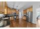 Bright kitchen with wooden cabinetry, stainless appliances, stylish lighting, and hardwood floors at 81 Northcliff Ct, Clayton, NC 27527