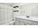 Bright bathroom with white vanity, tub with shower, floating shelves, and large mirror at 81 Olive Branch Dr, Smithfield, NC 27577