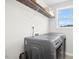 Bright laundry room featuring front load washer and dryer, wire shelving, and a window for natural light at 81 Olive Branch Dr, Smithfield, NC 27577