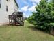 Green backyard featuring home, deck and surrounding tall trees at 857 Stable Fern Dr, Fuquay Varina, NC 27526