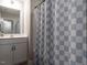 This bathroom is equipped with a single sink vanity, a mirror, and a shower with a checkered curtain at 857 Stable Fern Dr, Fuquay Varina, NC 27526