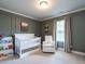 This darling Bedroom showcases chair rail detail, a plush chair, and charming decor at 857 Stable Fern Dr, Fuquay Varina, NC 27526