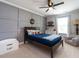 This darling bedroom includes wood paneled accent wall, plush chair, and a ceiling fan at 857 Stable Fern Dr, Fuquay Varina, NC 27526