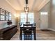 Elegant dining room with modern chandelier, wood floors, and large windows at 857 Stable Fern Dr, Fuquay Varina, NC 27526