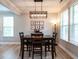 Elegant dining room with modern chandelier, wood floors, and large windows at 857 Stable Fern Dr, Fuquay Varina, NC 27526