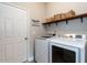 Laundry room featuring modern washer and dryer, storage shelves and bright lighting at 857 Stable Fern Dr, Fuquay Varina, NC 27526