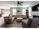 Comfortable living room featuring a large sectional sofa, ceiling fan, and fireplace adding a cozy touch at 857 Stable Fern Dr, Fuquay Varina, NC 27526