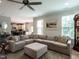 Comfortable living room featuring a large sectional sofa, ceiling fan and view of kitchen at 857 Stable Fern Dr, Fuquay Varina, NC 27526