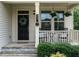 Inviting front porch featuring a black door, hanging plants, and stylish seating area at 857 Stable Fern Dr, Fuquay Varina, NC 27526