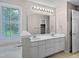 Bright bathroom with double sink vanity, white cabinets, and large mirror reflecting natural light from window at 8640 Swarthmore Dr, Raleigh, NC 27615