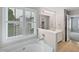 Bright bathroom with a large soaking tub, natural light and an attached shower at 8640 Swarthmore Dr, Raleigh, NC 27615