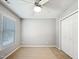 Bright bedroom with a ceiling fan, window with blinds and closet with white doors at 8640 Swarthmore Dr, Raleigh, NC 27615