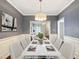 Formally, virtually staged dining room with seating for eight, stylish decor, and views into the adjacent living room at 8640 Swarthmore Dr, Raleigh, NC 27615