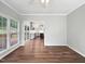 Dining room with natural light and wood floors leading to the outdoor patio and spacious kitchen at 8640 Swarthmore Dr, Raleigh, NC 27615