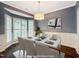 Bright and inviting, virtually staged dining room featuring a bay window and elegant table setting at 8640 Swarthmore Dr, Raleigh, NC 27615
