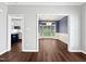 View of a dining room with a bay window and hardwood floors, open to the kitchen with white cabinets at 8640 Swarthmore Dr, Raleigh, NC 27615