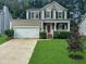 Charming two-story home featuring a manicured lawn, covered porch, and a two-car garage at 8640 Swarthmore Dr, Raleigh, NC 27615